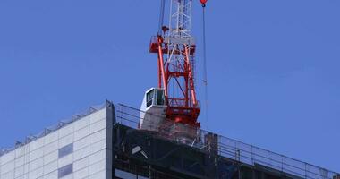 Stopping cranes at the top of the building at the business town in Tokyo telephoto shot video