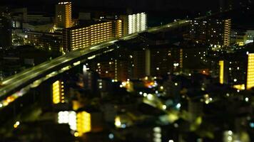 A night timelapse of miniature cityscape near the highway in Osaka tilt video