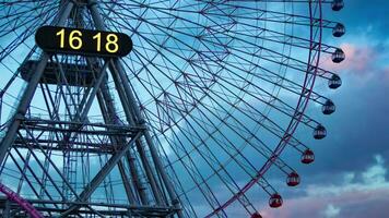 A dusk timelapse of rotating ferris wheel in Yokohama telephoto shot tilt video