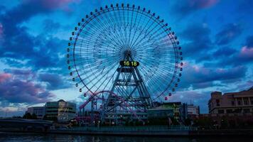 A dusk timelapse of rotating ferris wheel in Yokohama wide shot zoom video