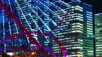 A night timelapse of rotating ferris wheel in Yokohama telephoto shot tilt video