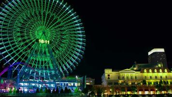 A night timelapse of rotating ferris wheel in Yokohama wide shot zoom video