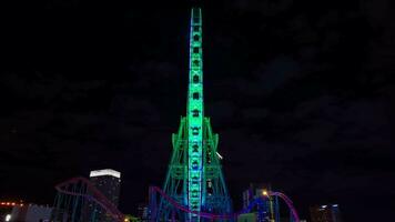 A night timelapse of rotating ferris wheel in Yokohama wide shot tilt video