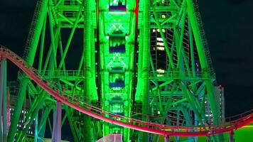 A night timelapse of rotating ferris wheel in Yokohama telephoto shot panning video