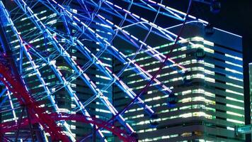 A night timelapse of rotating ferris wheel in Yokohama telephoto shot panning video