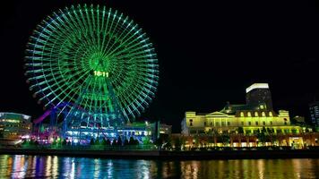 A night timelapse of rotating ferris wheel in Yokohama wide shot tilt video