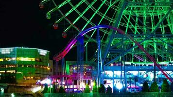 een nacht timelapse van roterend ferris wiel in yokohama telefoto schot kantelen video