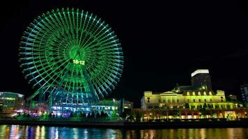 A night timelapse of rotating ferris wheel in Yokohama wide shot video