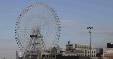 un giratorio ferris rueda a el urbano ciudad en Yokohama video