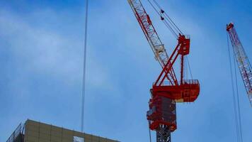 A timelapse of crane at the top of the building in Tokyo telephoto shot zoom video