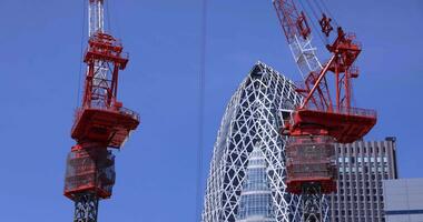 Stopping cranes at the top of the building at the business town in Tokyo telephoto shot video