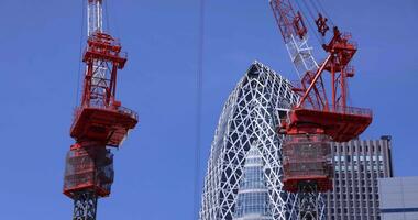 parada grúas a el parte superior de el edificio a el negocio pueblo en tokio telefotográfico Disparo video