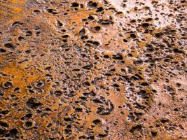 Many rugged holes on the rusty color concrete floor photo