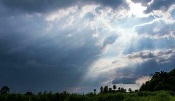 Beam of Sunlight behind dark clouds in the countryside photo