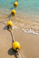 boya flotante y cuerda que divide el área en la playa. foto