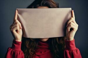 AI generated Enigmatic image Woman hiding face behind a sheet of paper photo