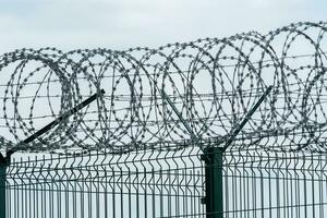 Security fence with a barbed wire. Fence with a barbed wire. photo