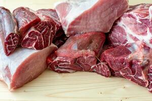 Different types of raw pork meat and beef. Raw meat on wooden table. photo