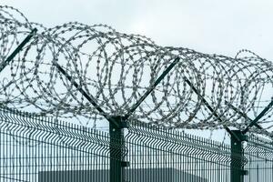 Security fence with a barbed wire. Fence with a barbed wire. photo