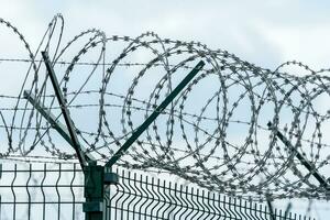 Security fence with a barbed wire. Fence with a barbed wire. photo