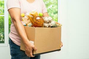 Volunteers putting various dry food in donation box for help people. photo