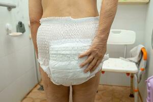 Asian senior woman patient wearing incontinence diaper in hospital, healthy strong medical concept. photo