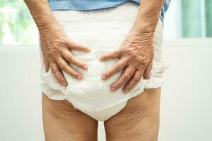 Asian senior woman patient wearing incontinence diaper in hospital, healthy strong medical concept. photo