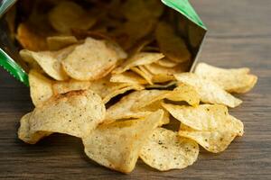 Potato chips, delicious spicy for crips, thin slice deep fried snack fast food in open bag. photo