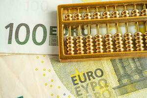 Gold abacus on Euro banknote money, economy finance exchange trade investment concept. photo