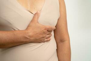 Asian woman patient checking and worry her breast, Breast Self Exam or BES, symbol of World Breast Cancer Day. photo