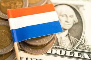 Stack of coins with Netherlands flag and US dollar banknotes. photo
