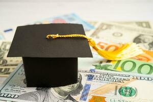 Graduation gap hat on Euro and US dollar banknotes money, Education study fee learning teach concept. photo