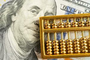 Gold abacus on USA dollar banknote money, economy finance exchange trade investment concept. photo