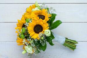 Wedding bouquet of sunflower on a wooden background. Top view with copy space. photo