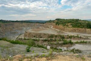 Opencast mining quarry with machinery. Quarrying of stones for construction works. Mining industry in quarry. photo