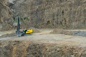 Opencast mining quarry with mining drilling machine. Mining in the granite quarry. Mining industry. photo