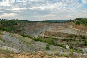 Opencast mining quarry with machinery. Quarrying of stones for construction works. Mining industry in quarry. photo