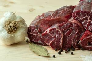 Fresh beef with ingredients for cooking on wooden board photo