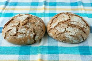 Fresh rustic bread on a checkered towel photo