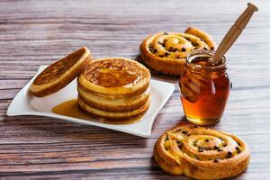 Pancakes with liquid honey on wooden background. photo
