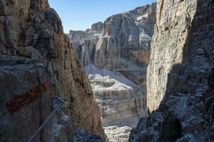 Fixed-rope Route, climbing a via ferrata route. Italian Alps. Mountain tourism in the Dolomites. Region Brenta, Italy. photo