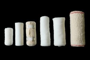 Different sizes of medical bandages. Medical bandages isolated on black background. Medical equipment. photo