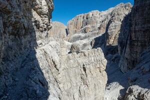 Fixed-rope Route, climbing a via ferrata route. Italian Alps. Mountain tourism in the Dolomites. Region Brenta, Italy. photo