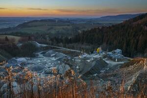 Mining in a granite quarry Sloupno and in the background a beautiful landscape at sunset. photo