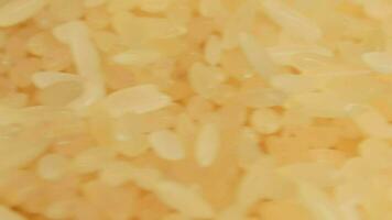 trocken ungekocht parboiled Reis Haufen rotierend - - Makro. ein Stapel von roh lange Korn Reis - - Nahansicht. asiatisch Küche und Kultur. gesund Essen Zutaten. Diät Essen video
