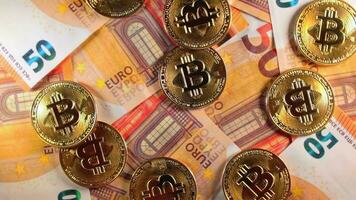 bitcoin monete su il 50 Euro banconote - superiore Visualizza. Euro i soldi denaro contante e criptovaluta. un' lotto di cinquanta Euro fatture. finanze, scambio, blockchain e elettronico i soldi concetto - lento rotazione sinistra video