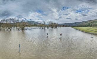 zumbido imagen de el alemán río principal durante un inundar con inundado arboles y tráfico señales en el banco foto