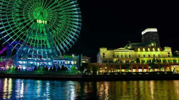 A night timelapse of rotating ferris wheel in Yokohama wide shot panning video