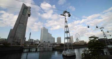 ein rotierend Ferris Rad in der Nähe von das Seilbahn im Yokohama video