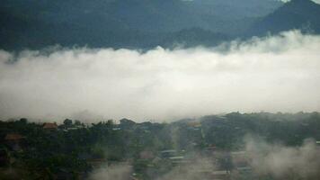 fluente nebbia sopra il cittadina, il nebbia flussi attraverso il montagna foresta, sole splendente in tropicale foresta, nebbia derive attraverso montagna creste nel il mattina video